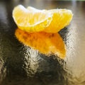 two slices of tangerine on a golden background fruit reflection orange background