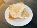 Two slices toast bread in the white plate on wooden table. Royalty Free Stock Photo