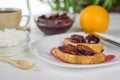 Two slices of toasted French bread smeared with plum jam on a white plate. Royalty Free Stock Photo