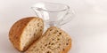 Two slices of whole grain bread on a white background. Transparent glass saucepan. Royalty Free Stock Photo