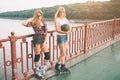 Two slim and young women and roller skates. One female has an inline skates and the other has a quad skates. Girls Royalty Free Stock Photo