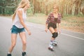 Two slim and young women and roller skates. One female has an inline skates and the other has a quad skates. Girls Royalty Free Stock Photo