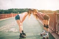 Two slim and young women and roller skates. One female has an inline skates and the other has a quad skates. Girls Royalty Free Stock Photo