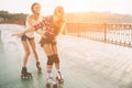 Two slim and young women and roller skates. One female has an inline skates and the other has a quad skates. Girls Royalty Free Stock Photo