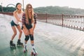 Two slim and young women and roller skates. One female has an inline skates and the other has a quad skates. Girls Royalty Free Stock Photo