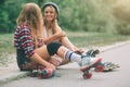 Two slim and young women and roller skates. One female has an inline skates and the other has a quad skates. Girls Royalty Free Stock Photo