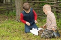 Two small boys trying to light a fire in a field