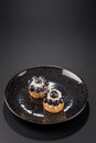 Two small cakes with blueberries and creamy cream on a black plate. Vertical. Copy space. Royalty Free Stock Photo