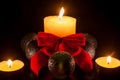 Two small candles around a bigger candle with christmas globes a Royalty Free Stock Photo