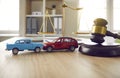 Gavel and two crashed toy cars on lawyer's or judge's table illustrating car insurance concept Royalty Free Stock Photo