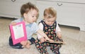 Two small children sit on the floor and read books. Girl and boy Royalty Free Stock Photo