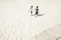 Two small children are walking along the sandy beach. Cute boy and girl hold hands and go to the sea Royalty Free Stock Photo