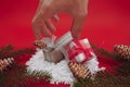 Two small Christmas gift boxes and pine branches and brown cones. A hand takes a gift.  on red background Royalty Free Stock Photo