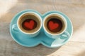 Two small cups of coffee accompanied by heart shaped saucer