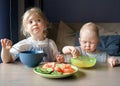 Two kids eating soup and vegetables for lunch at home Royalty Free Stock Photo