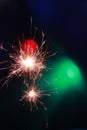 Two small fireworks that are burning in vertical photo format