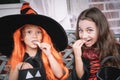Two small girls in costumes celebrate halloween by eating candy Royalty Free Stock Photo