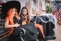 Two small girls in costumes celebrate halloween by eating candy Royalty Free Stock Photo