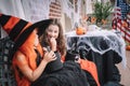 Two small girls in costumes celebrate halloween by eating candy Royalty Free Stock Photo