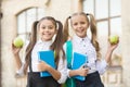 Two small girls ready to study. do homework together. sisters at lunch break with apple. healthy and happy childhood