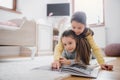 Two small girls sisters indoors in bedroom at home, reading a book. Royalty Free Stock Photo