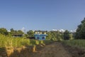 Two small houses in the countryside in green rice fields against a background of forest and snow-capped mountains and a clear blue Royalty Free Stock Photo