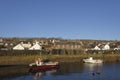 Two small Inshore Fishing boats moored next to the harbour Wall