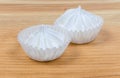 Meringue cookies in ruffled paper molds on wooden surface closeup Royalty Free Stock Photo