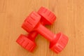 Two small pink dumbbells on wooden background Royalty Free Stock Photo