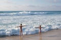 Two small pretty child girls standing in front of Atlantic ocean with open hands. Children play on ocean beach. Royalty Free Stock Photo