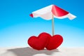 Two small red heart under the umbrella on beach Royalty Free Stock Photo