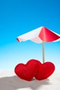 Two small red heart under the umbrella on beach Royalty Free Stock Photo