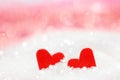 Two small red paper hearts lying next to each other surrounded by sugar crystals against a bokeh pink and white background. Royalty Free Stock Photo