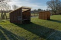 Two small rustic football dugouts in a field, the home dugout in the foreground Royalty Free Stock Photo