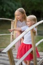 Two sisters are standing on wooden bridge in the park Royalty Free Stock Photo