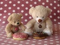 Two teddy bears with frosted donuts