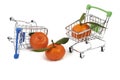 Two small toy cart for groceries from the supermarket and three tangerines with green leaves Royalty Free Stock Photo