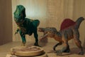 Two small toy dinosaurs over a wooden bowl of food on the shelf Royalty Free Stock Photo