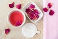 Two small white bowl with rose water (toner), dry rose petals and cotton pad. Homemade cosmetics. Royalty Free Stock Photo