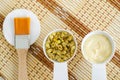 Two small white bowls with dry immortelle flowers and organic herbal facial mask cream, salve, balm for natural skincare