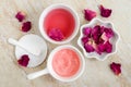 Two small white bowls with rose water toner and jelly rose mask. Dry rose petals and cotton pad. Royalty Free Stock Photo