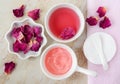 Two small white bowls with rose water toner and jelly rose mask. Dry rose petals, cotton pad. Royalty Free Stock Photo