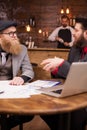 Two smart bearded businessmen in black and gray suit having a meeting in a coffee shop Royalty Free Stock Photo