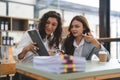 Two smart multiethnic business people working together with laptop while talking about job news in the office. Royalty Free Stock Photo