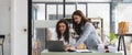 Two smart multiethnic business people working together with laptop while talking about job news in the office. Panoramic Royalty Free Stock Photo