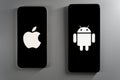 Two smartphones at an angle displaying Apple and Android logos on black screens. Royalty Free Stock Photo