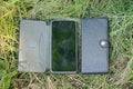 two smartphones in black leather cases lie on green grass Royalty Free Stock Photo