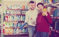 Two smiling adult people selecting detergents in the store Royalty Free Stock Photo