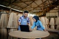 two smiling Asian entrepreneurs using laptop computer at woodcraft shop Royalty Free Stock Photo