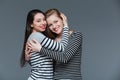 Two smiling attractive young women standing and hugging Royalty Free Stock Photo